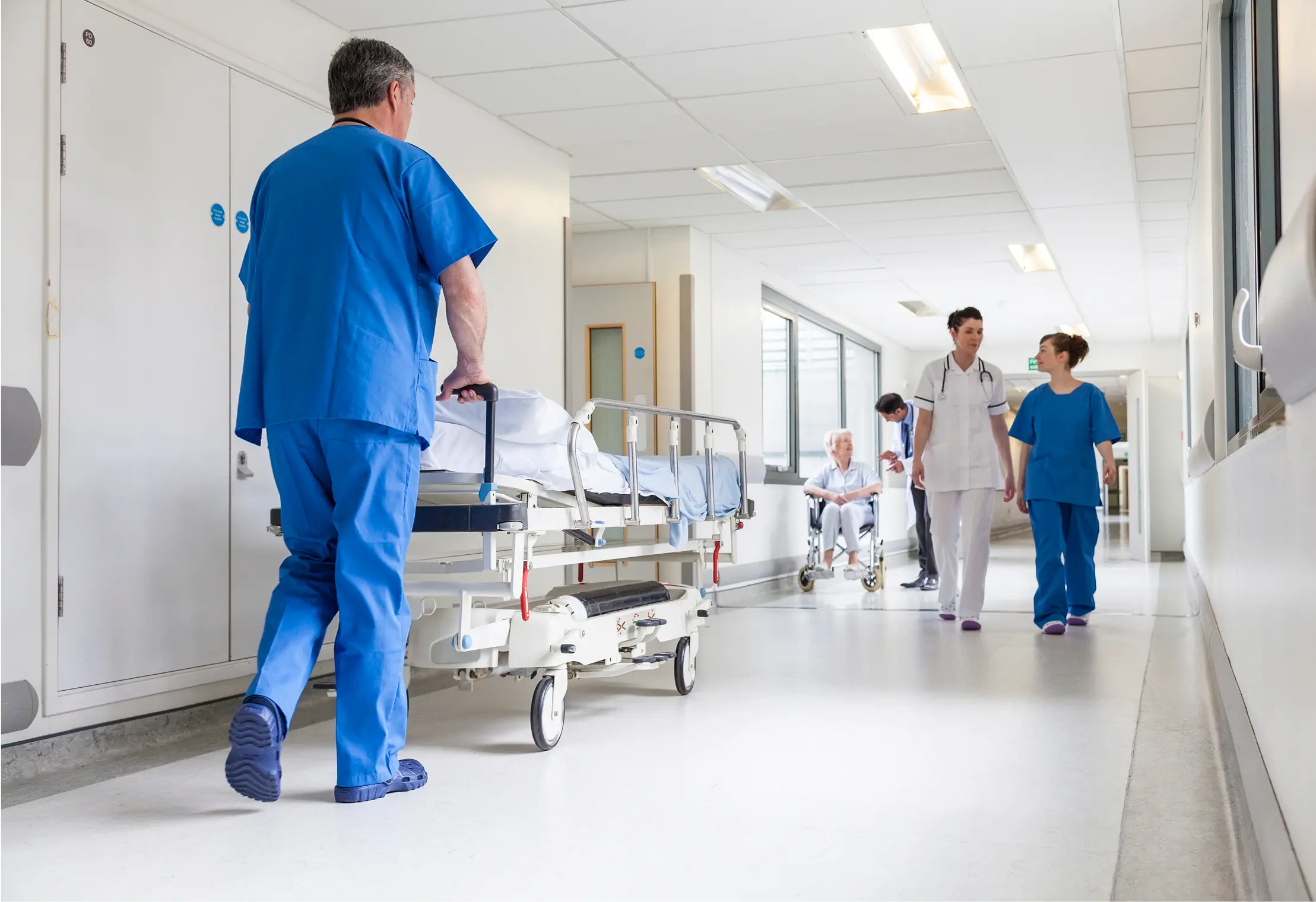 Hospital staff walking in a bright corridor.